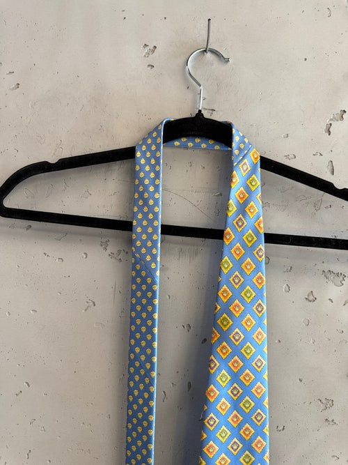BERLIN VINTAGE CORNER blue silk tie with geometric diamond pattern in yellow, orange, and green.