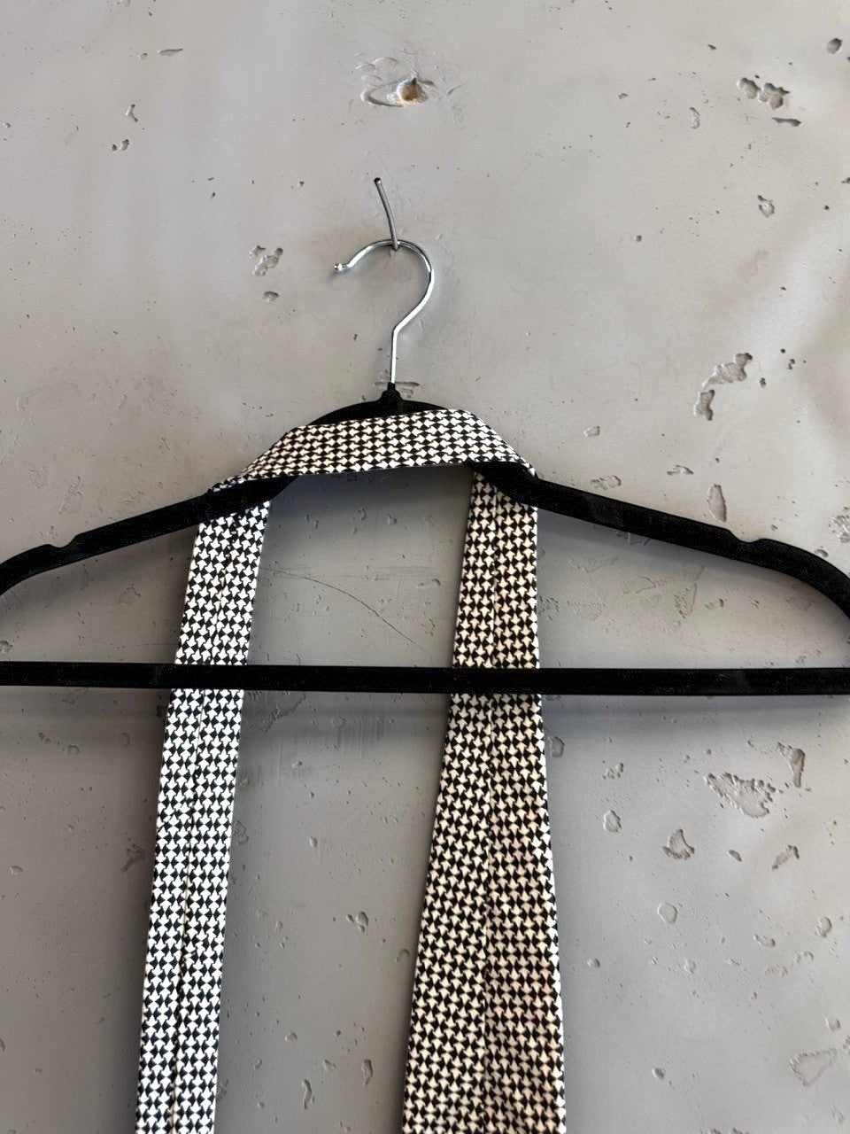 BERLIN VINTAGE CORNER BOSS Hugo Boss formal necktie featuring a black and white geometric micro-pattern on a hanger.