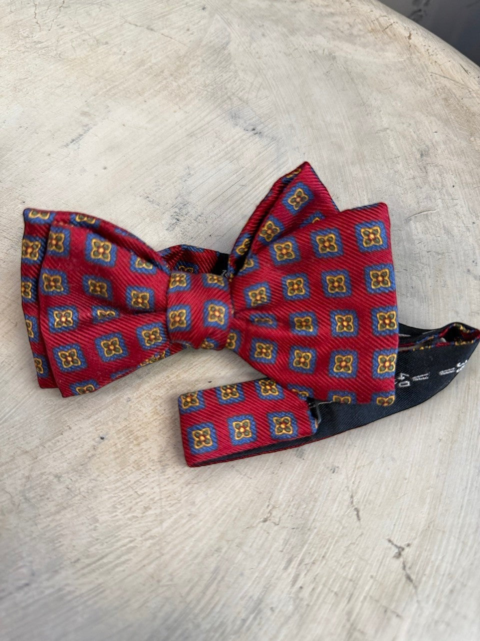 BERLIN VINTAGE CORNER burgundy silk bow tie with blue squares and gold floral pattern. Adjustable strap.