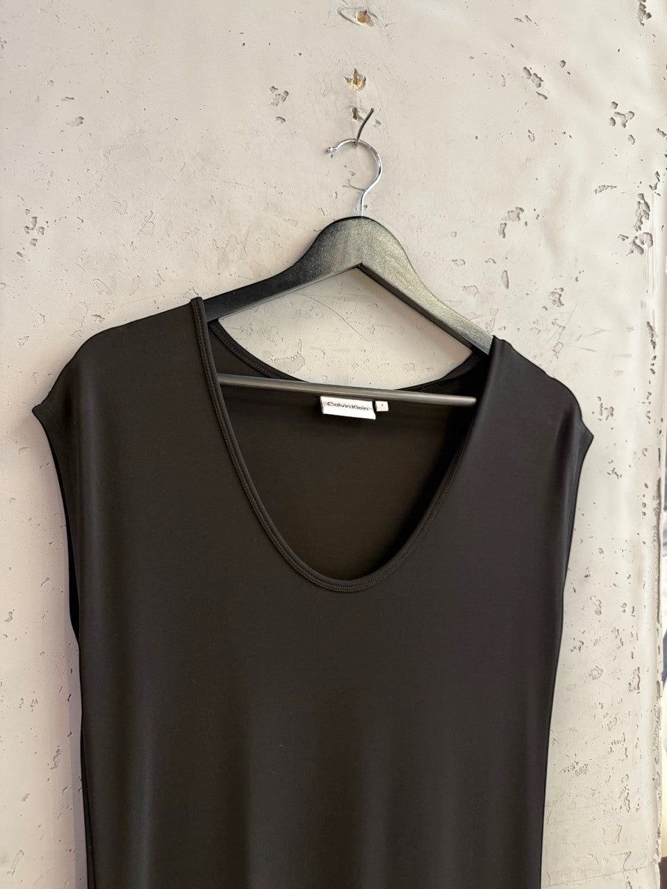 BERLIN VINTAGE CORNER Calvin Klein black sleeveless midi dress with a V-neckline hanging on a black hanger.