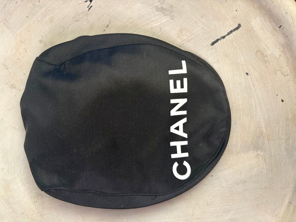 BERLIN VINTAGE CORNER black CHANEL newsboy cap with bold white logo lettering on a textured surface