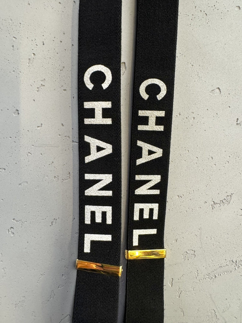 BERLIN VINTAGE CORNER black elastic CHANEL suspenders with white logo print and gold-tone hardware details