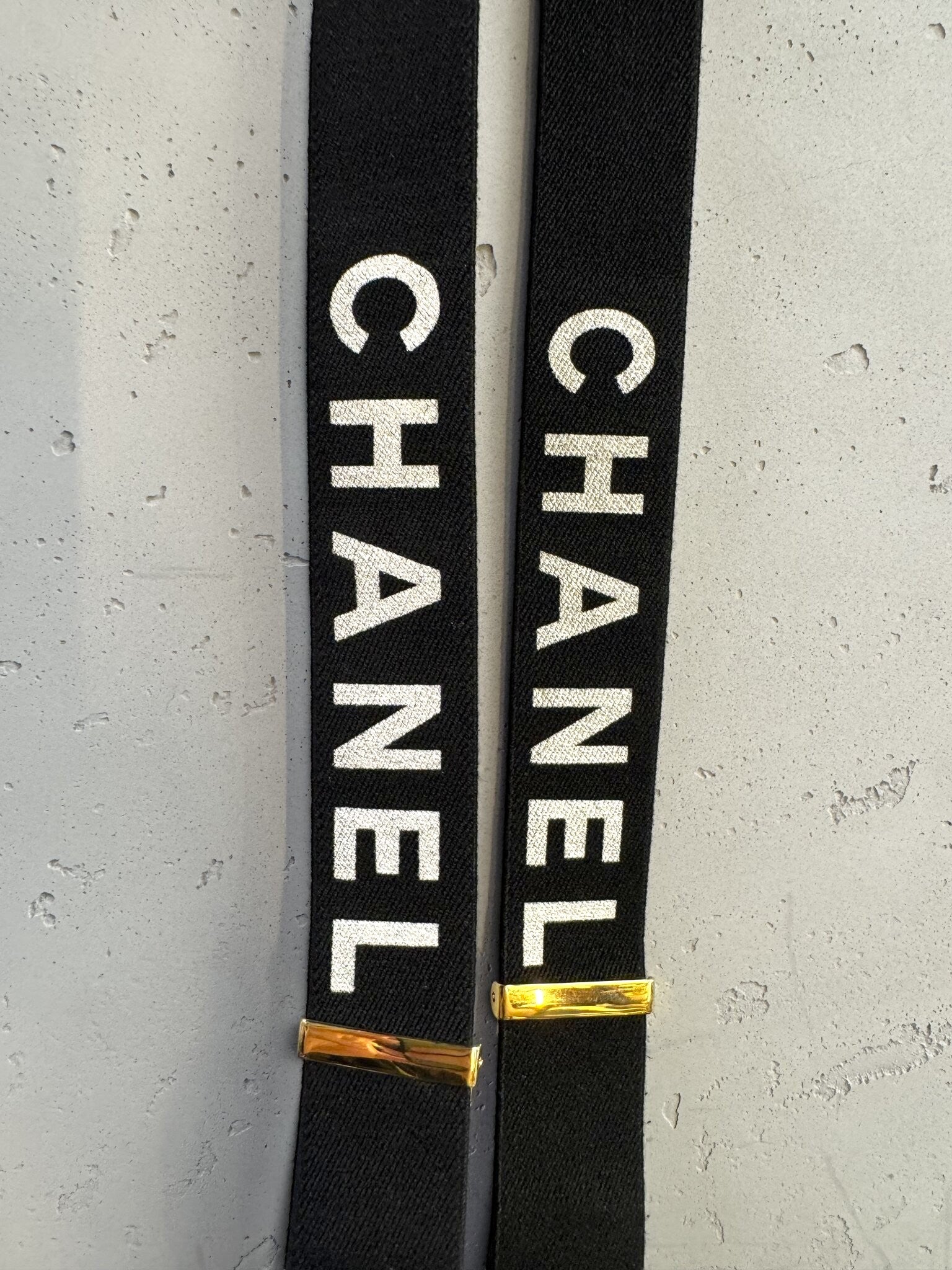 BERLIN VINTAGE CORNER black elastic CHANEL suspenders with white logo print and gold-tone hardware details