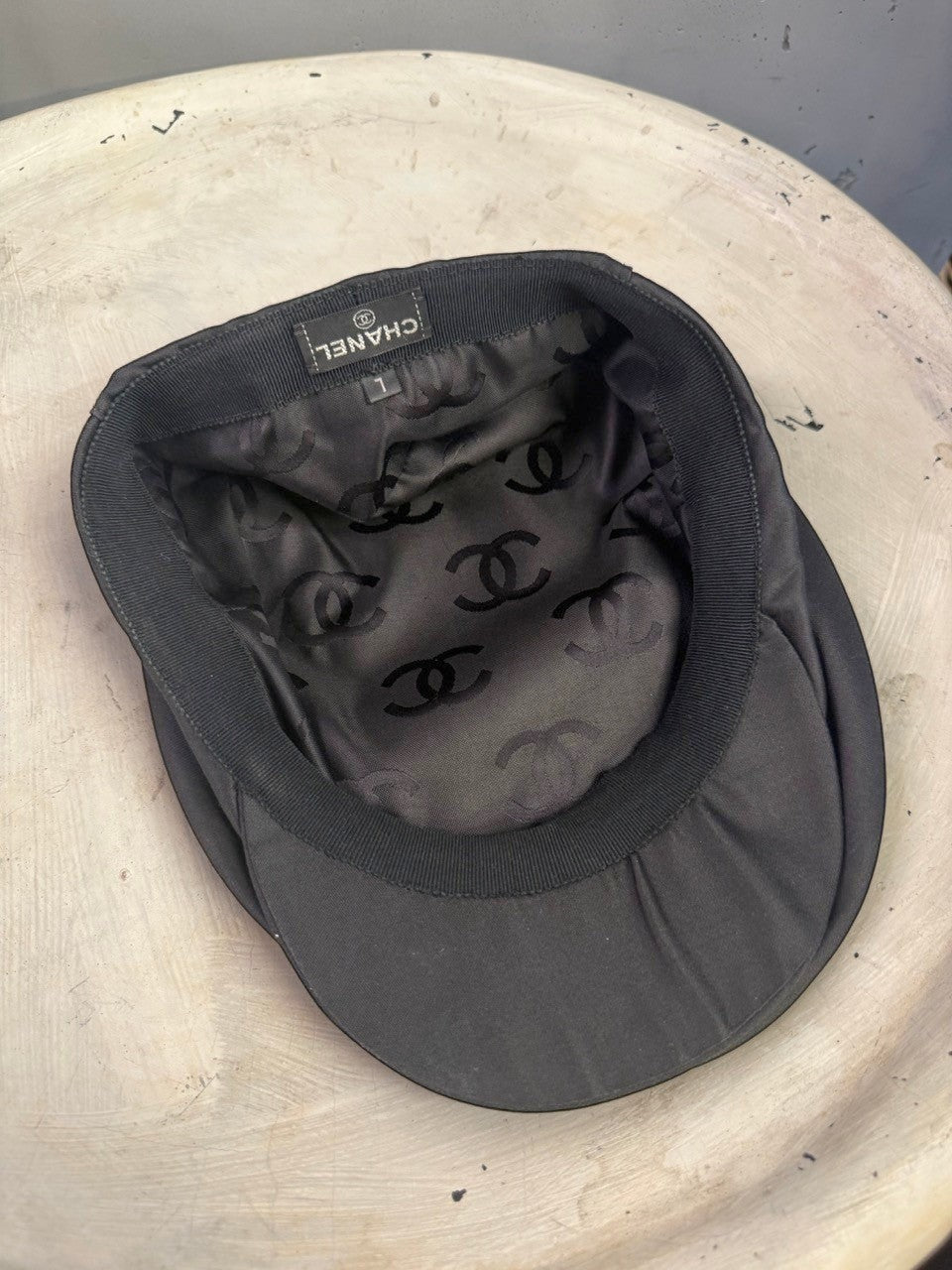 BERLIN VINTAGE CORNER black CHANEL newsboy cap interior showing branded silk lining with CC logo pattern