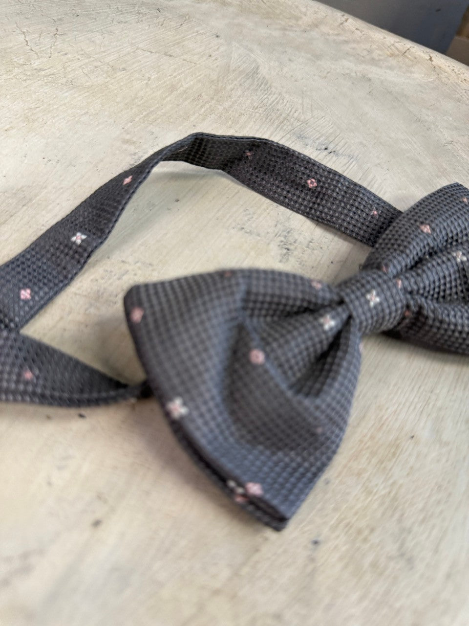 BERLIN VINTAGE CORNER charcoal grey textured bow tie with small pink floral pattern, pre-tied with adjustable neckband.
