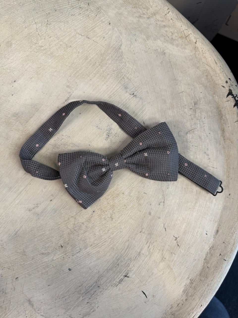 BERLIN VINTAGE CORNER charcoal grey textured bow tie with small pink floral pattern, pre-tied with adjustable neckband.