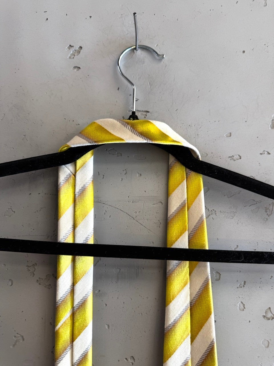 BERLIN VINTAGE CORNER Christian Lacroix yellow and white diagonal striped necktie hanging on a black hanger
