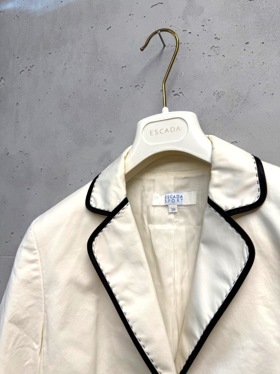 BERLIN VINTAGE CORNER cream blazer with black piping and contrast stitching. Classic single-button closure, flap pockets, three-quarter sleeves.