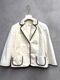 BERLIN VINTAGE CORNER cream blazer with black piping, single-button closure, flap pockets, and three-quarter sleeves.