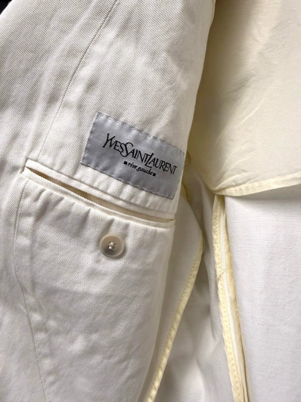 BERLIN VINTAGE CORNER cream cotton blend blazer with notched lapel, two-button closure, and gold-tone buttons.