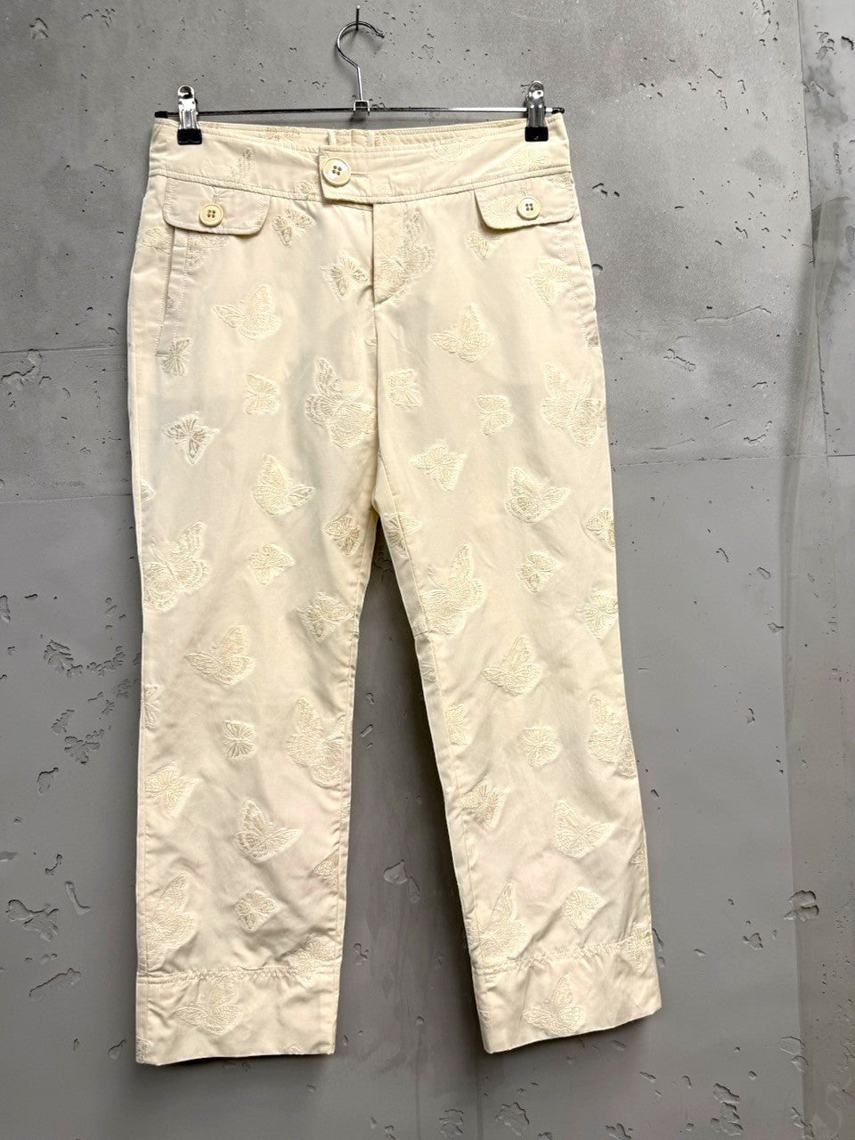 BERLIN VINTAGE CORNER cream trousers with all-over embroidered butterflies and button-fly closure.