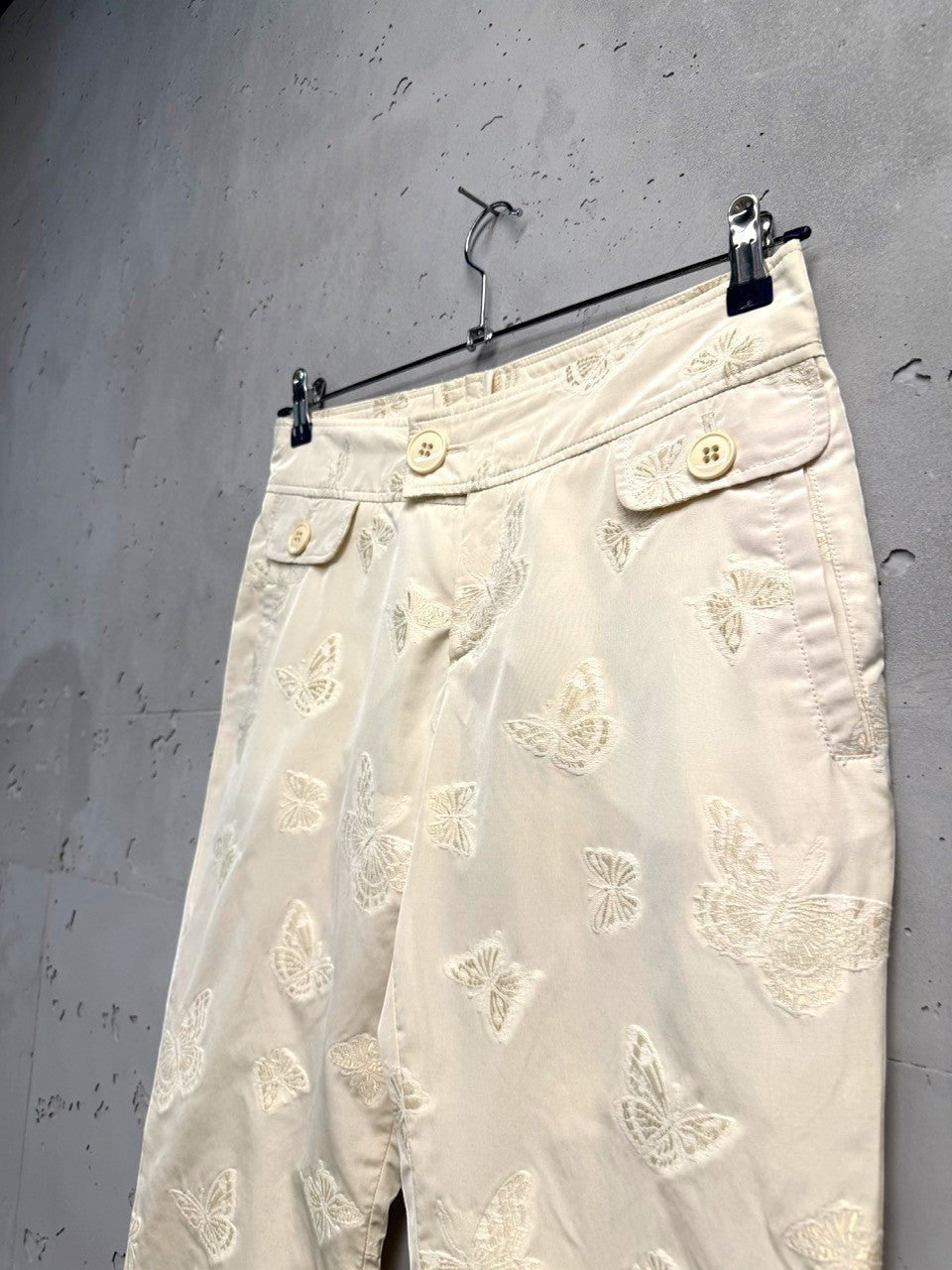 BERLIN VINTAGE CORNER cream trousers with all-over embroidered butterflies and button-fly closure.