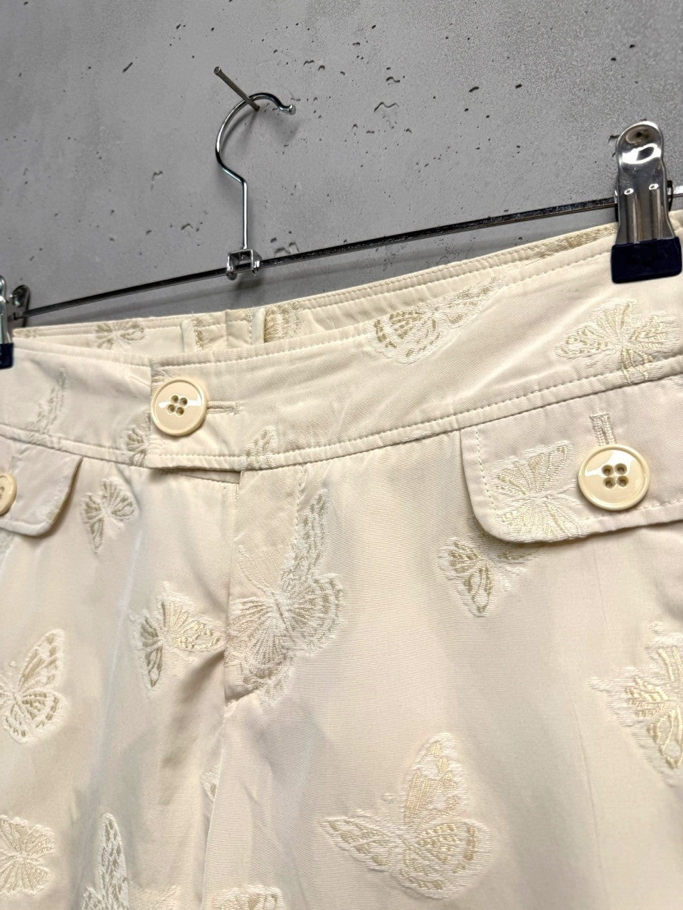 BERLIN VINTAGE CORNER cream trousers with all-over embroidered butterflies and button-fly closure.