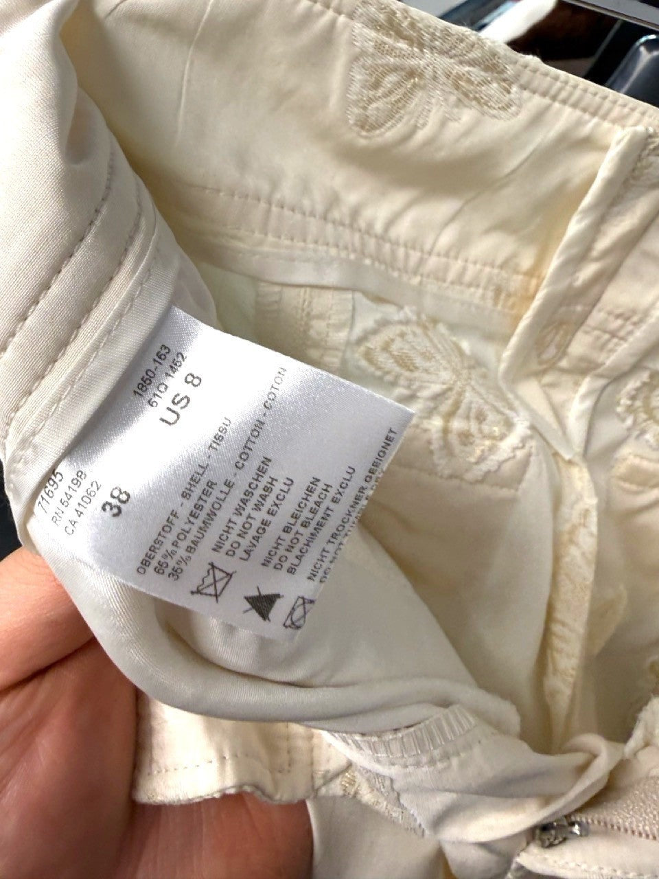 BERLIN VINTAGE CORNER cream trousers with all-over embroidered butterflies. Tailored fit with button-fly closure.
