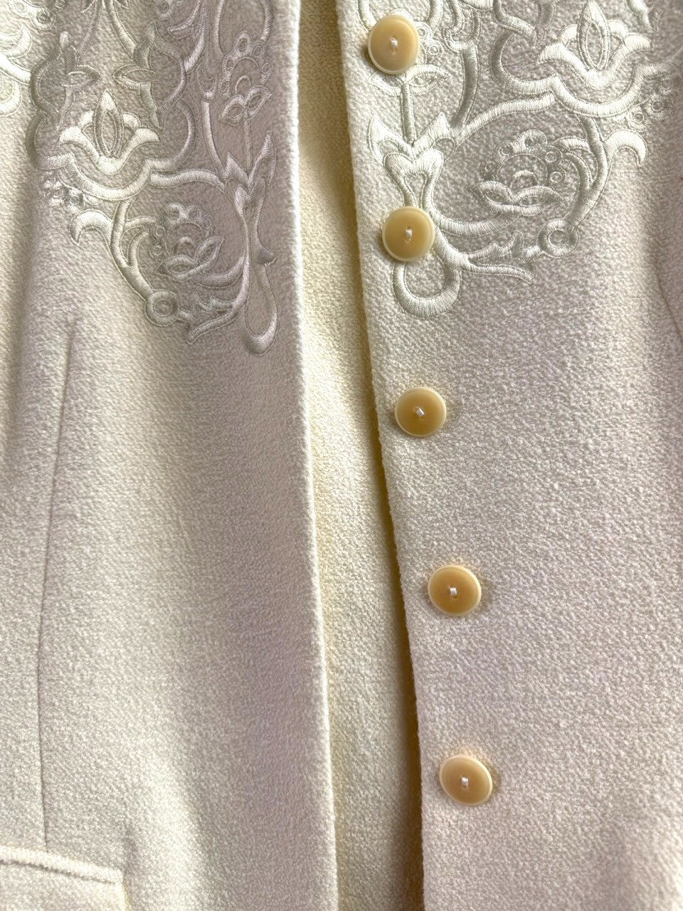 BERLIN VINTAGE CORNER cream wool silk blend jacket and skirt set with tonal embroidery and button closure.