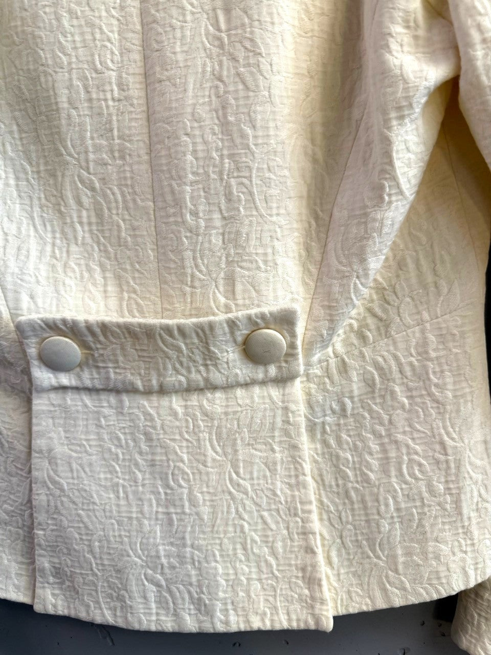 BERLIN VINTAGE CORNER cream blazer with tonal floral jacquard texture and back tab detail with fabric-covered buttons