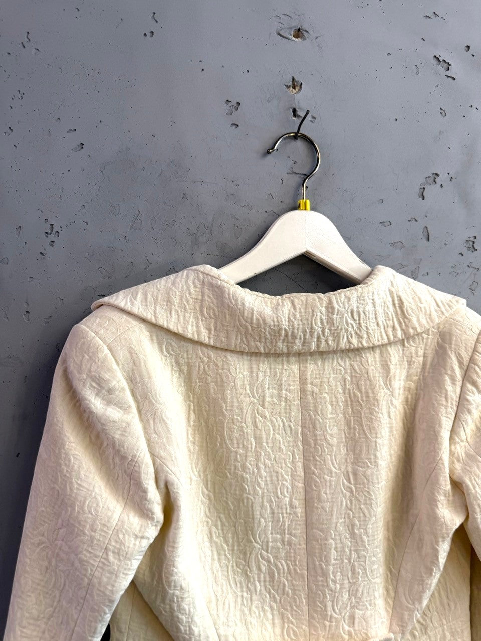 BERLIN VINTAGE CORNER cream blazer with tonal floral jacquard texture and wide collar, hanging on a white hanger.