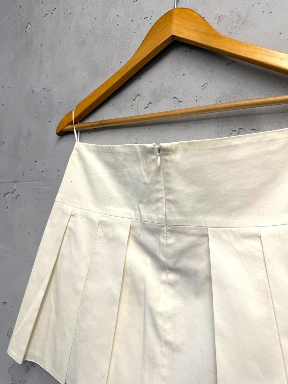 BERLIN VINTAGE CORNER cream cotton blend high-waisted pleated mini skirt with concealed back zipper.