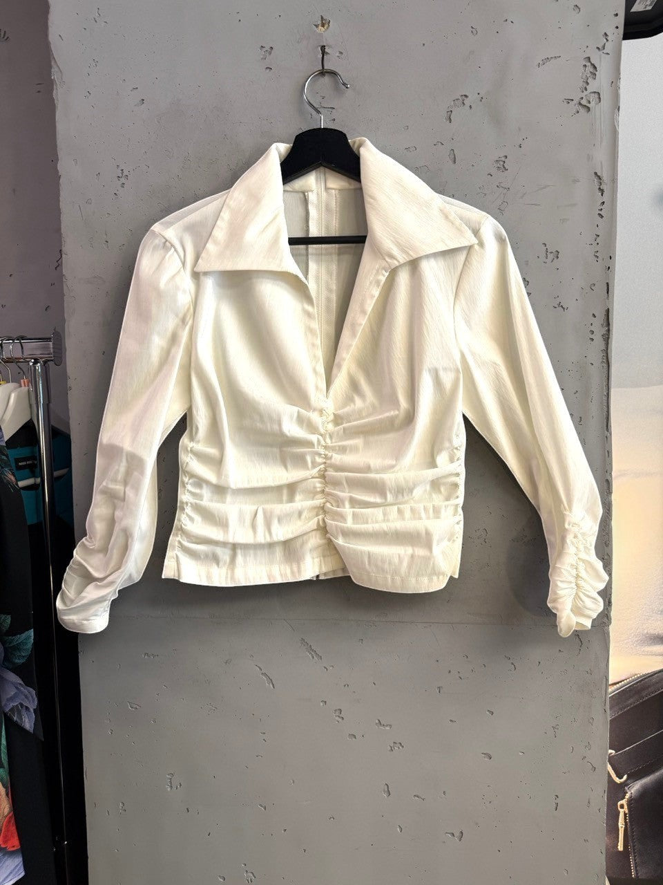 BERLIN VINTAGE CORNER cream long sleeve blouse with a collared neckline and ruched front detailing on a hanger.