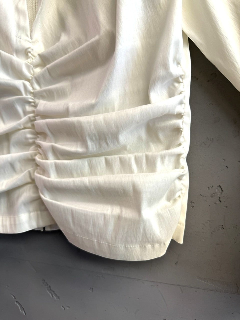 BERLIN VINTAGE CORNER cream long sleeve blouse featuring delicate ruched side detailing and a textured fabric finish.