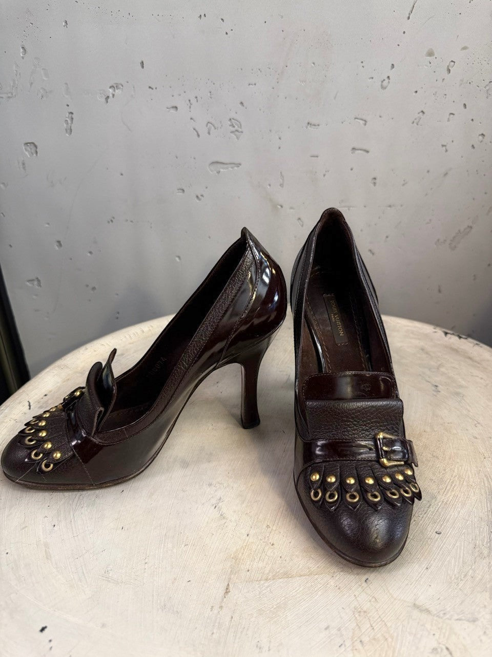 BERLIN VINTAGE CORNER dark brown leather loafer heels with fringe, gold hardware, and buckle detail.