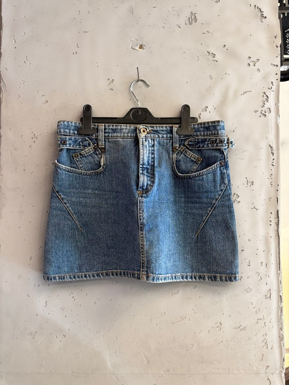 BERLIN VINTAGE CORNER blue denim mini skirt with unique pocket design and adjustable buckle details.