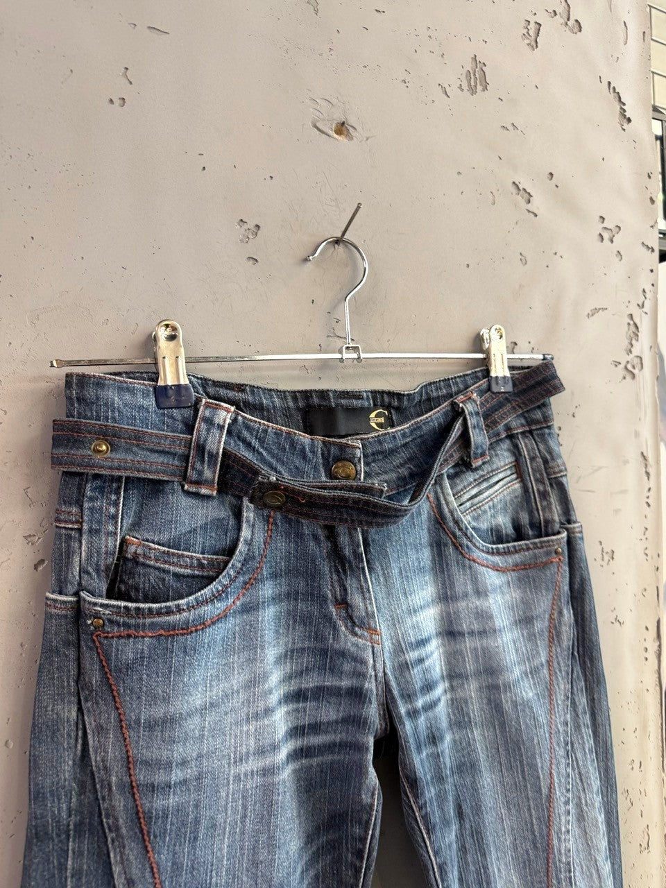 BERLIN VINTAGE CORNER mid-wash denim jeans with integrated belt and orange stitching. Distressed detailing.