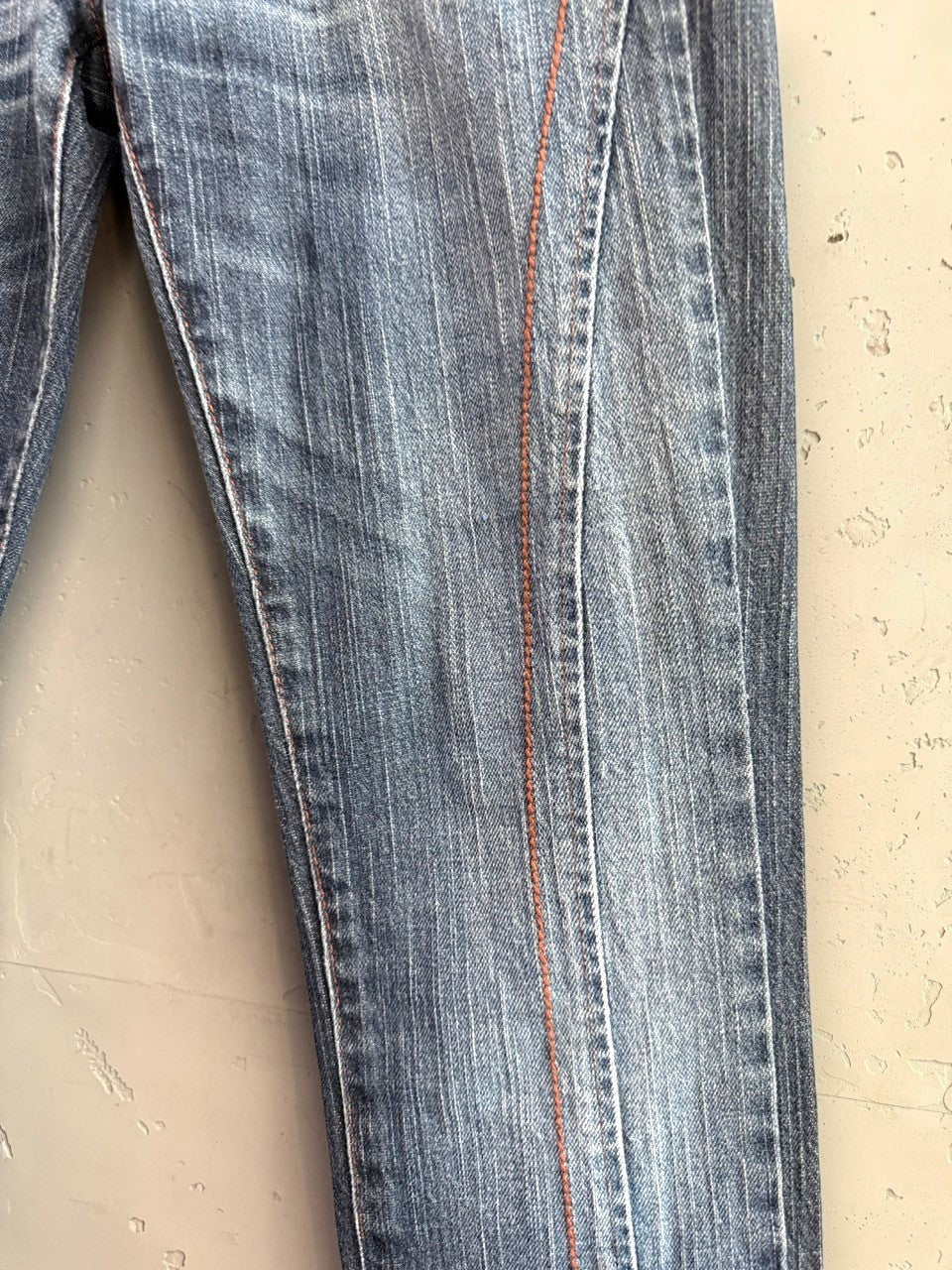 BERLIN VINTAGE CORNER mid-wash distressed denim jeans with integrated belt and orange stitching.