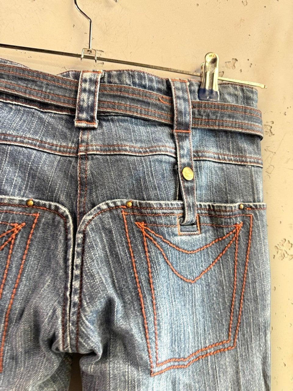 BERLIN VINTAGE CORNER mid-wash denim jeans with integrated belt and orange stitching. Distressed detailing.