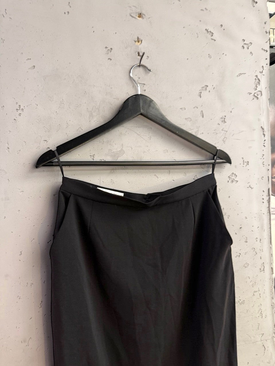 BERLIN VINTAGE CORNER Dolce & Gabbana black midi skirt with a minimalist tailored silhouette hanging on a black hanger.