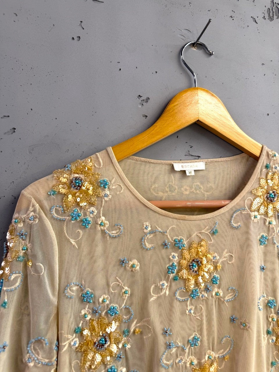 BERLIN VINTAGE CORNER sheer mesh blouse with short sleeves, embellished with gold and turquoise floral embroidery, beads, and sequins.