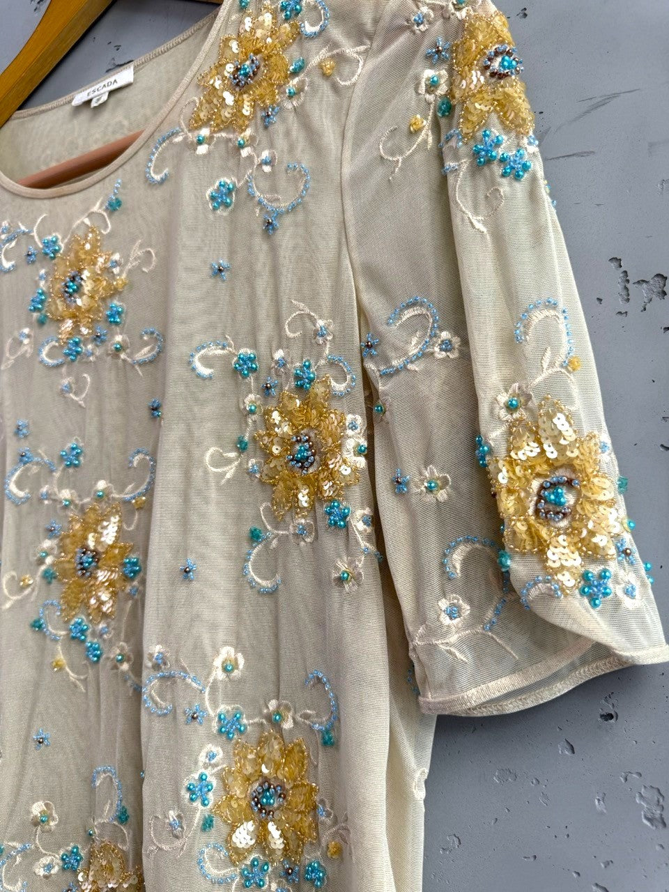 BERLIN VINTAGE CORNER sheer mesh blouse with short sleeves, embellished with gold and turquoise beads, sequins, and floral embroidery.