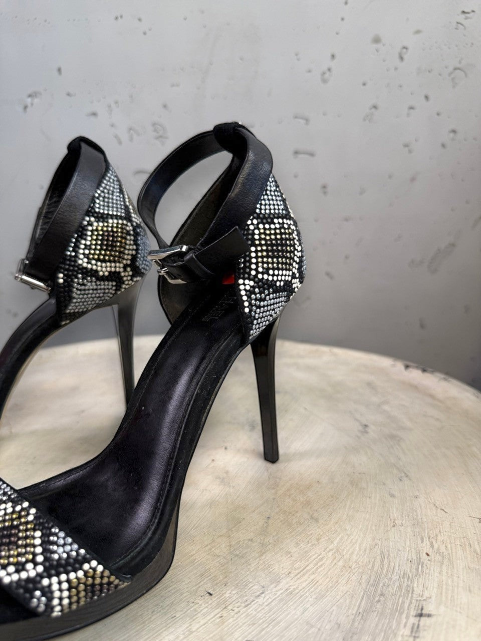 BERLIN VINTAGE CORNER black suede stiletto heels with rhinestone embellished ankle strap and snake print detail.