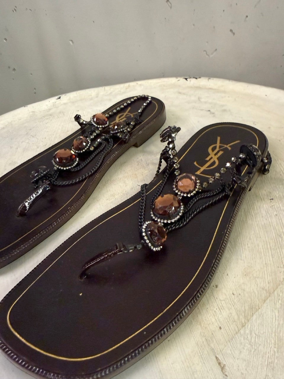 BERLIN VINTAGE CORNER dark brown leather thong sandals with rhinestone and amber stone embellishments and YSL logo.
