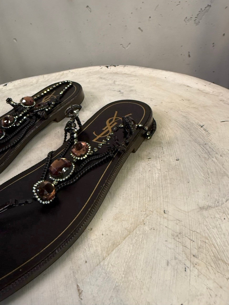 BERLIN VINTAGE CORNER dark brown leather thong sandals with rhinestone and amber-toned stone embellishments.