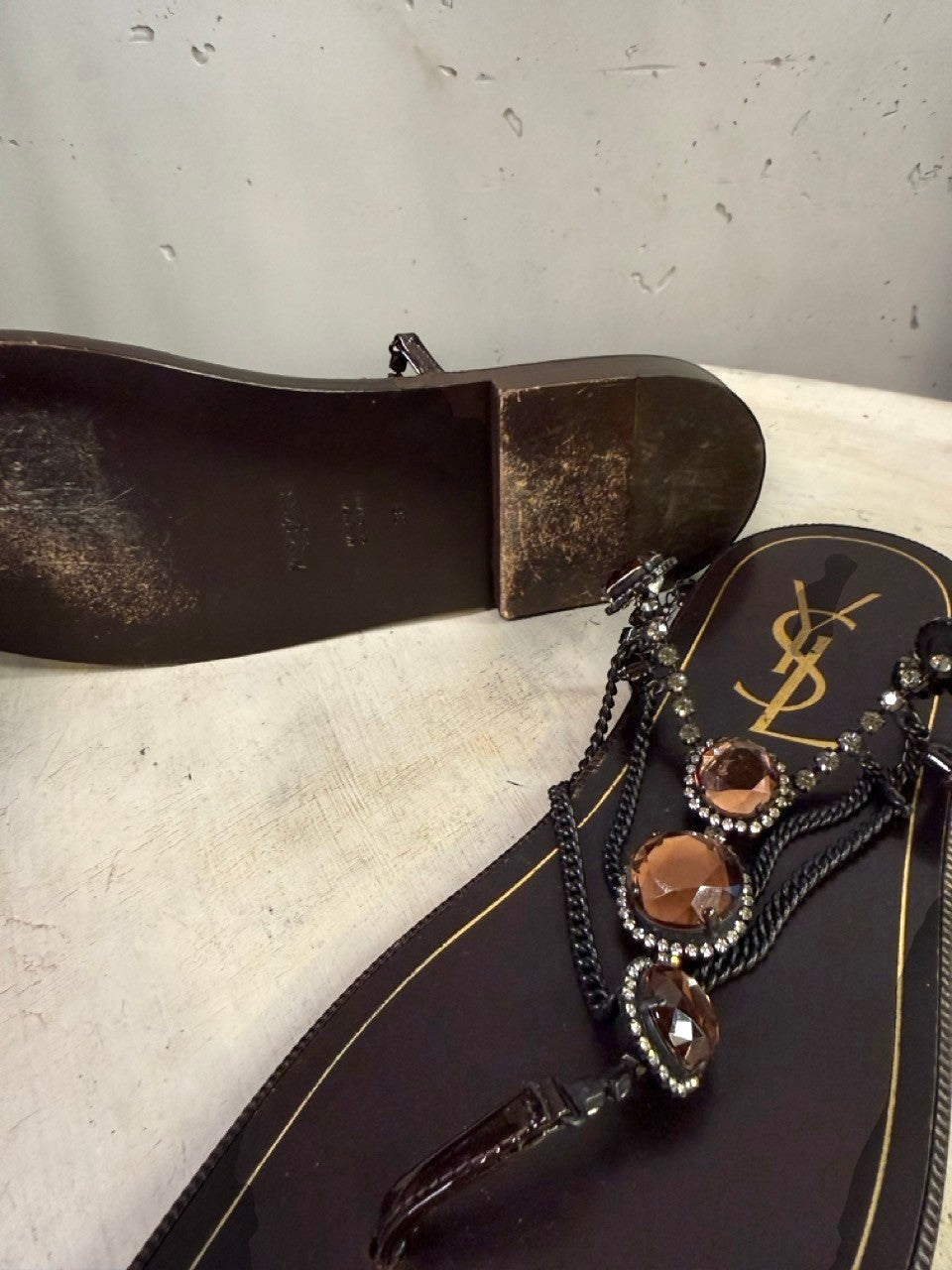 BERLIN VINTAGE CORNER dark brown leather thong sandals with rhinestone and amber-toned stone embellishments and YSL logo.