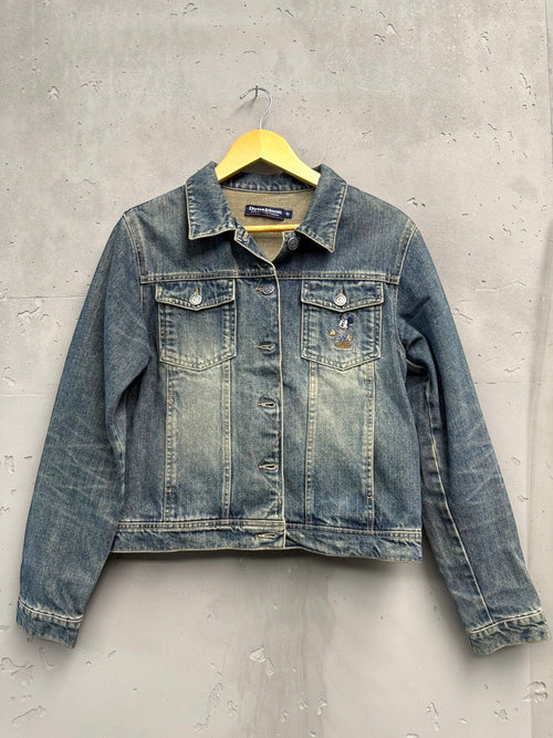BERLIN VINTAGE CORNER blue washed denim trucker jacket with embroidered Mickey Mouse motif on chest pocket.