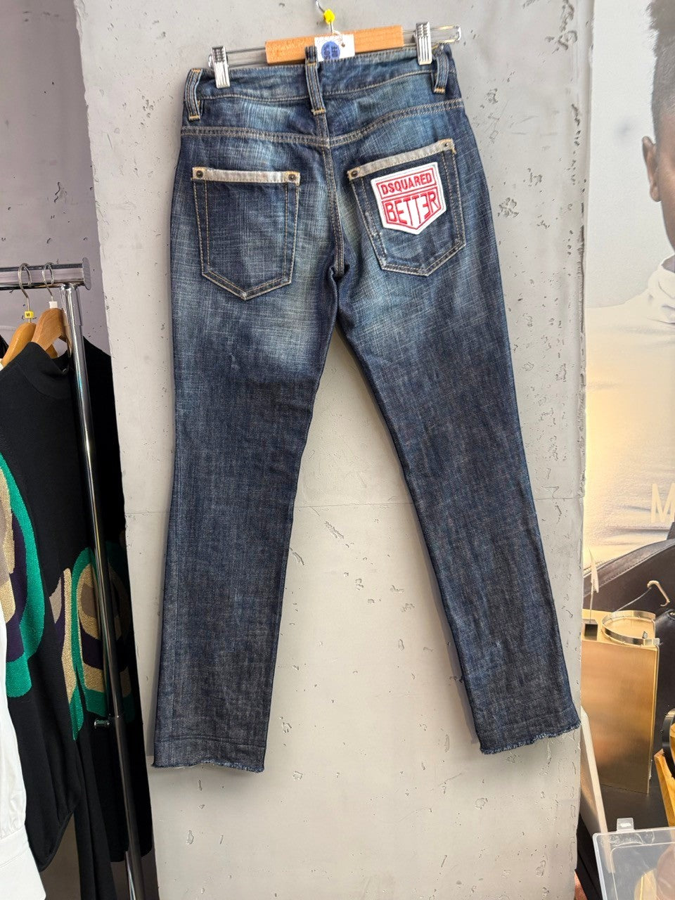 BERLIN VINTAGE CORNER blue denim jeans with distressed finish and embroidered patches, featuring 'Dsquared Better' logo.