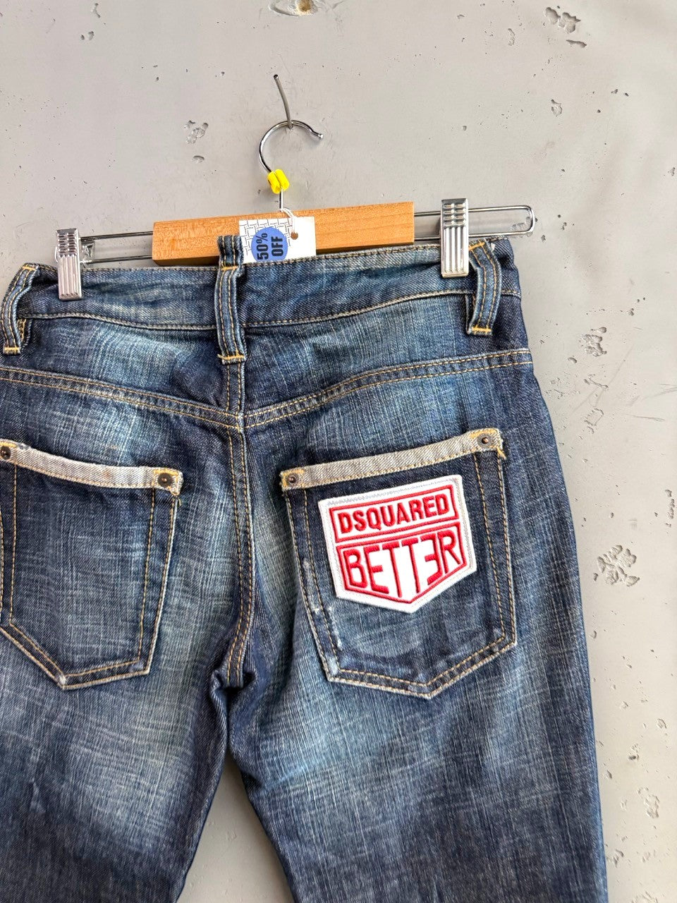 BERLIN VINTAGE CORNER blue denim jeans with distressed finish and embroidered patches. Features "Dsquared Better" patch.