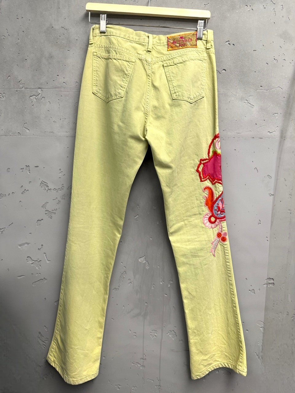 BERLIN VINTAGE CORNER light yellow denim flare jeans with embroidered paisley design on left leg in pink, red, and blue.