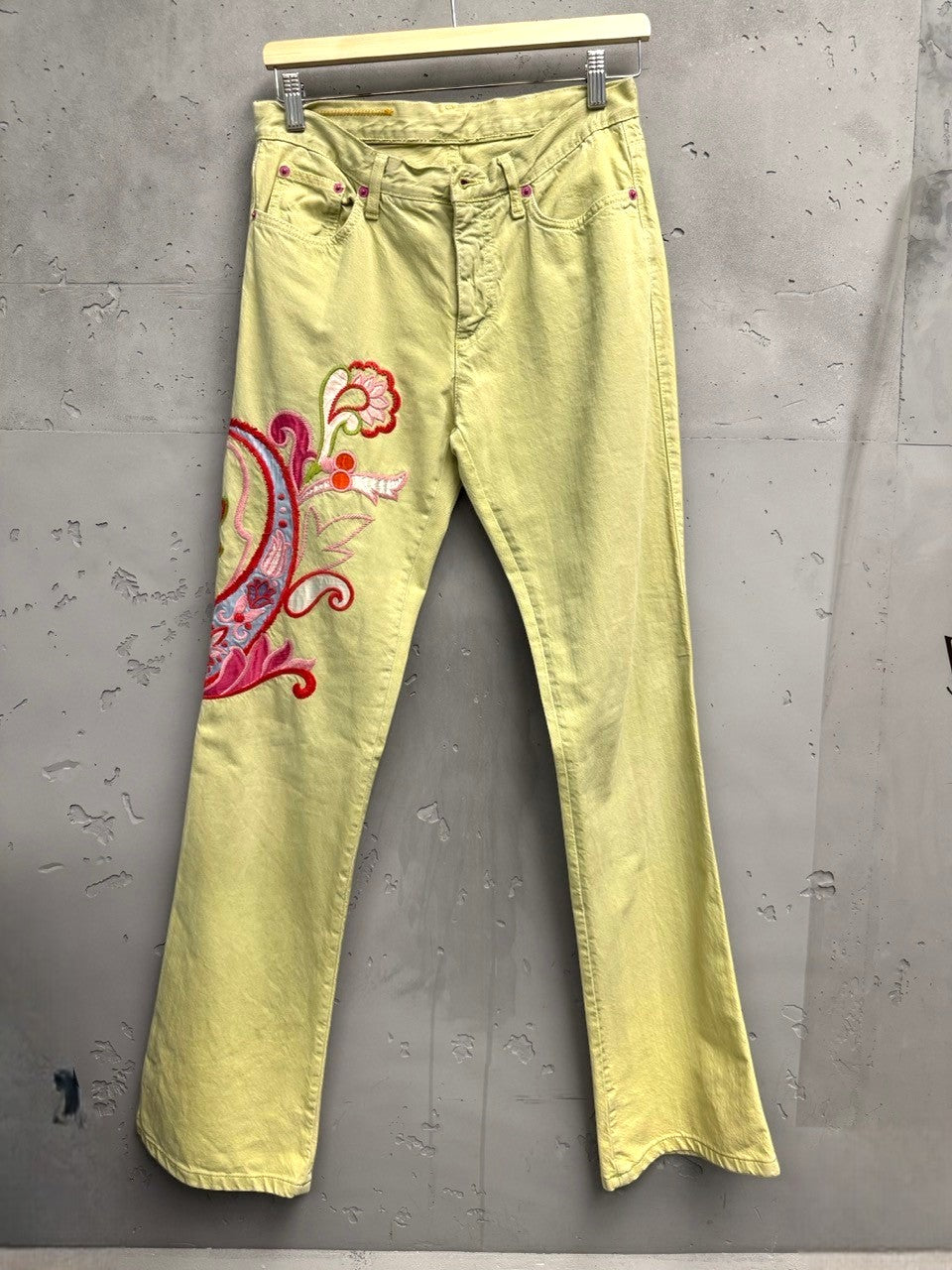 BERLIN VINTAGE CORNER light yellow denim flare jeans with embroidered pink, red, and blue paisley design on left leg.