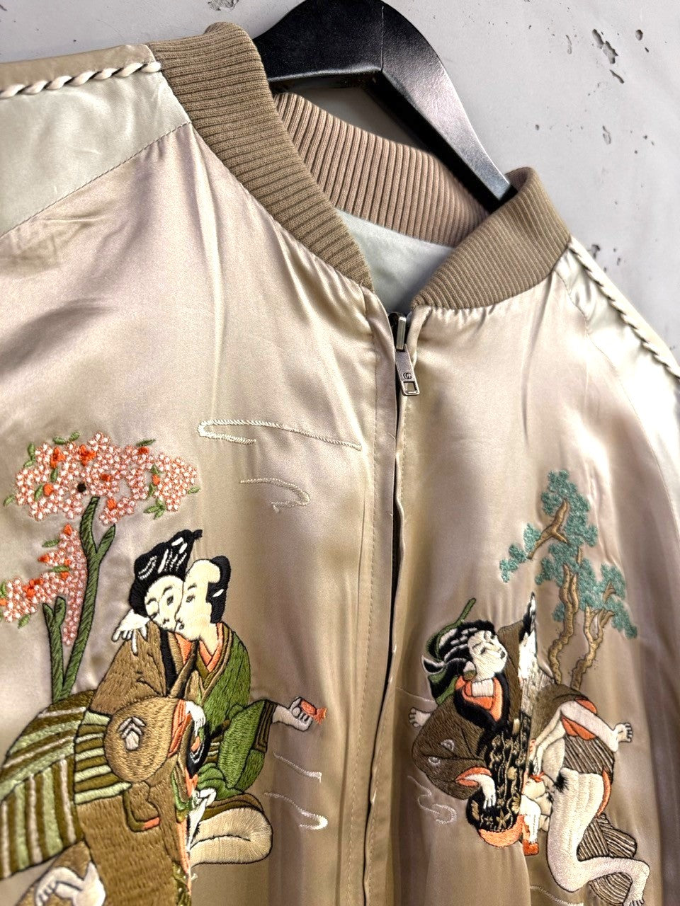BERLIN VINTAGE CORNER champagne satin bomber jacket with traditional Japanese embroidery of figures and cherry blossoms.
