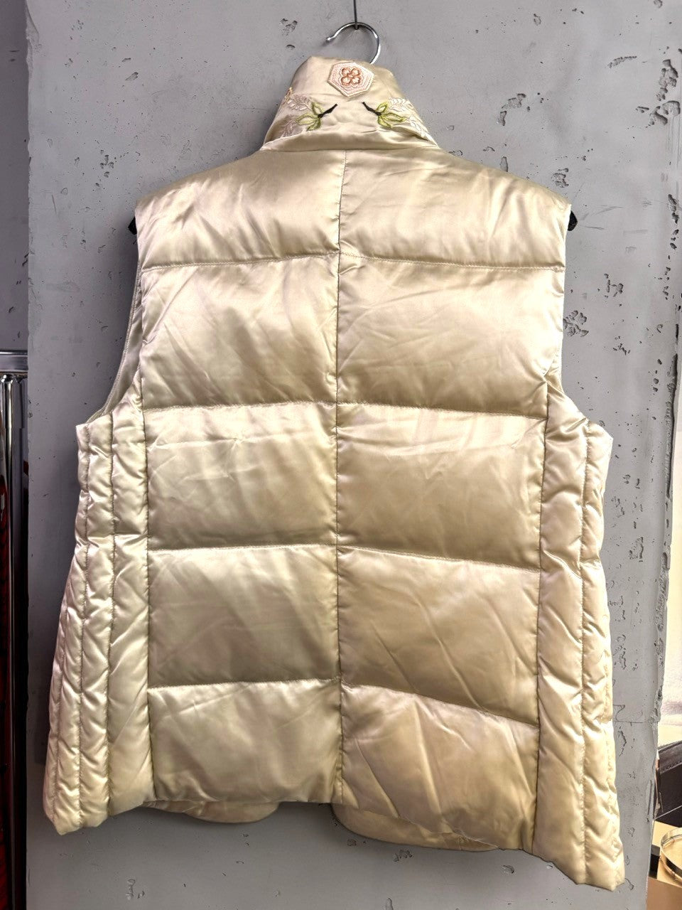BERLIN VINTAGE CORNER champagne satin puffer vest with floral embroidery on the high collar and quilted design.