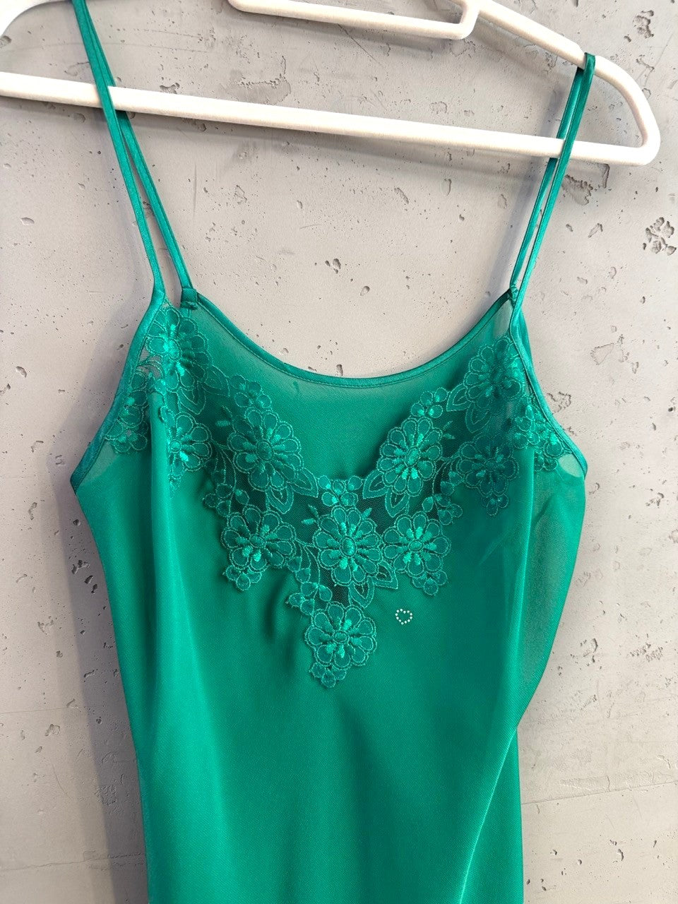 BERLIN VINTAGE CORNER emerald green sheer camisole with floral lace neckline and a small rhinestone heart detail.