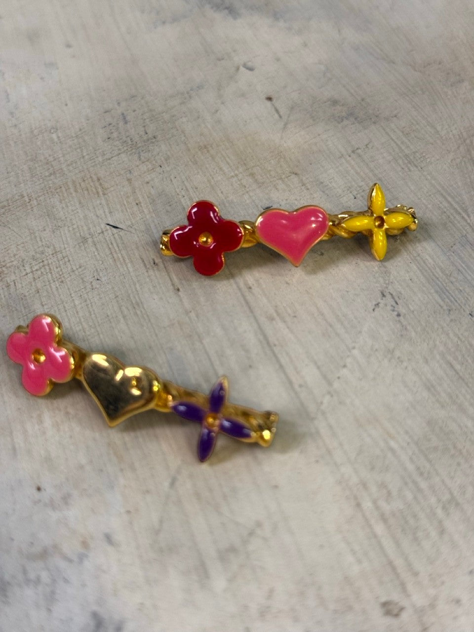 BERLIN VINTAGE CORNER enamel charm hair clips set with gold-tone base, featuring red flower, pink heart, yellow flower, pink flower, gold heart, and purple flower charms.