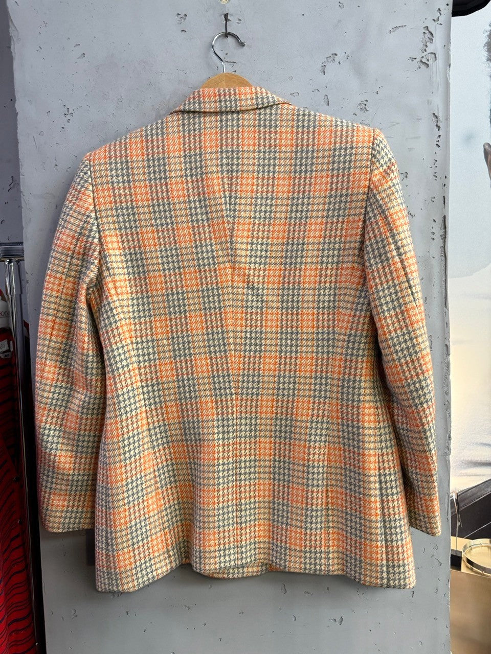 Back view of a BERLIN VINTAGE CORNER Escada Margaretha Ley blazer in orange and grey plaid wool-blend fabric.
