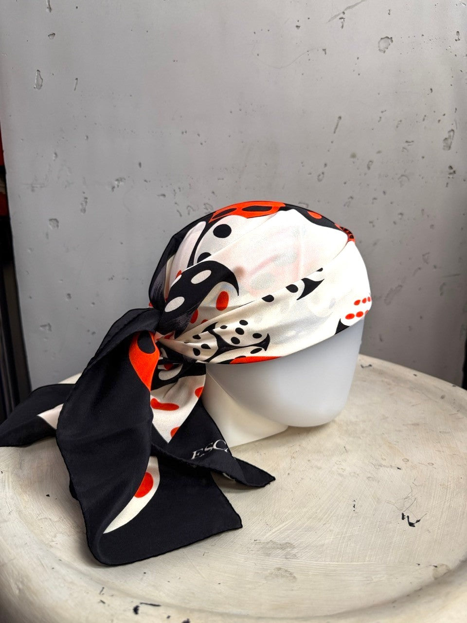 BERLIN VINTAGE CORNER ESCADA silk scarf with black, white, and red dice print tied on a mannequin head