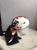 BERLIN VINTAGE CORNER ESCADA silk scarf with black, white, and red dice print tied on a mannequin head