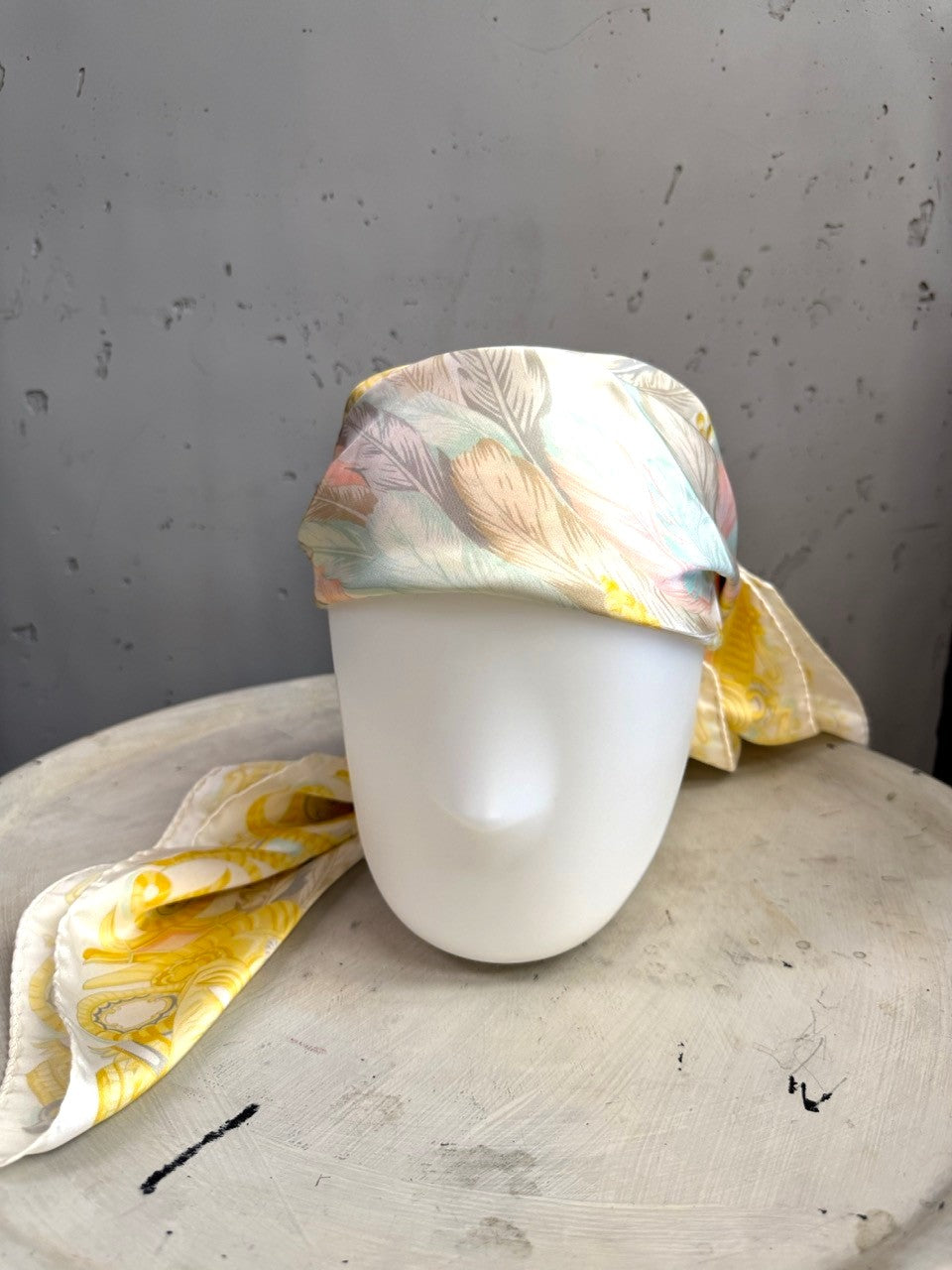 BERLIN VINTAGE CORNER Escada vintage silk scarf with pastel feather print styled as a headscarf on a mannequin