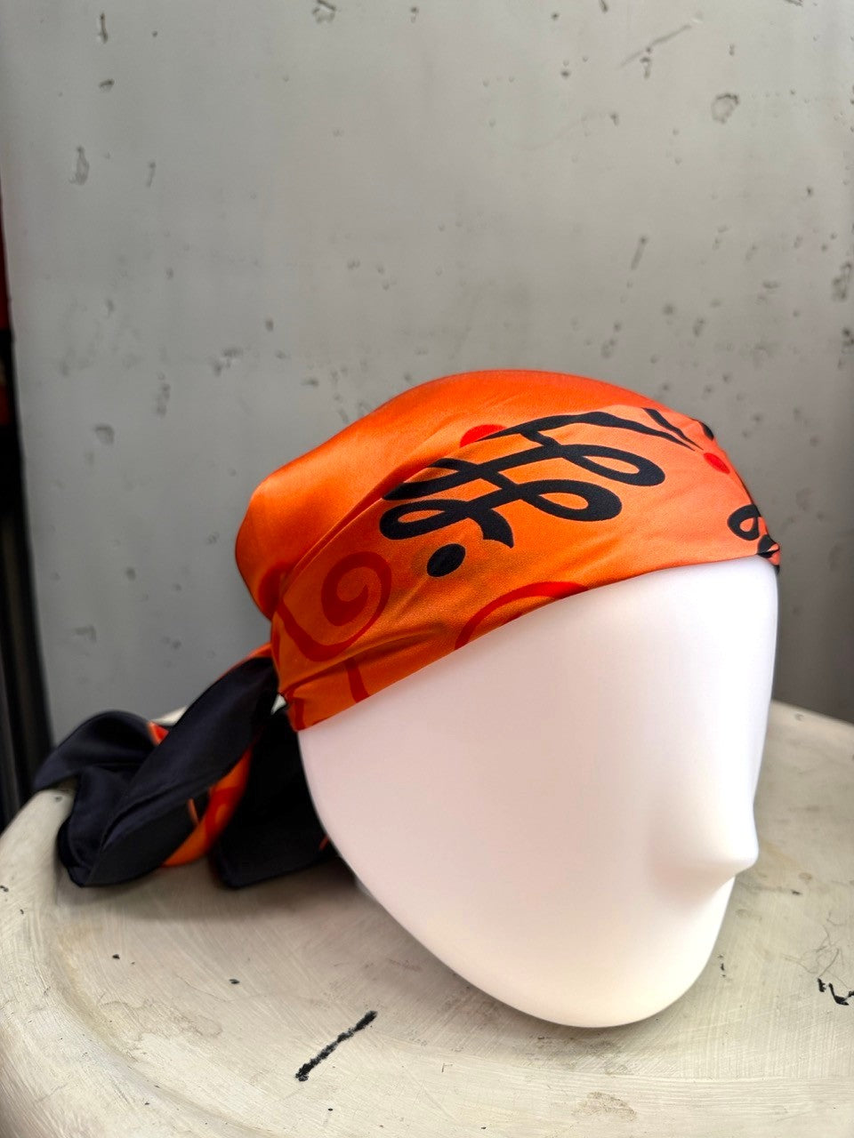 BERLIN VINTAGE CORNER vintage ESCADA silk scarf in vibrant orange and black with ornate scrollwork patterns on a mannequin